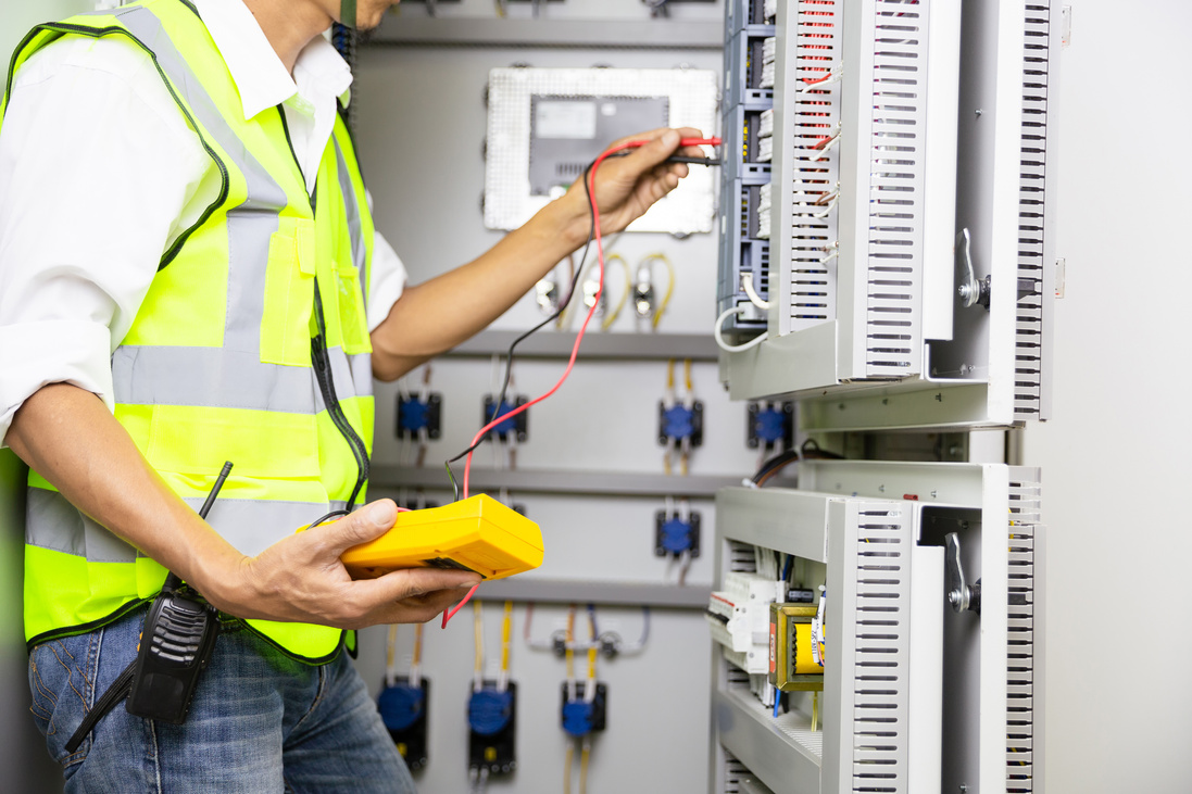 Electrical Engineer Repairing a Switchbox Using a Multimeter